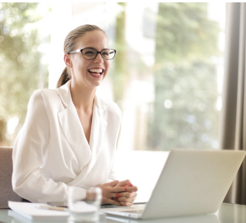 Professionnelle souriante devant son ordinateur portable